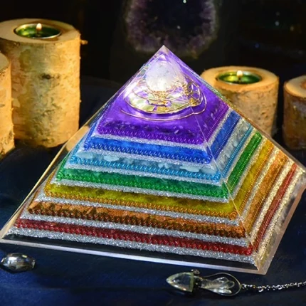 Orgonite crystal pyramid with natural stones like red jasper, aventurine, and topaz, amplifying orgone energy for healing and chakra balancing.